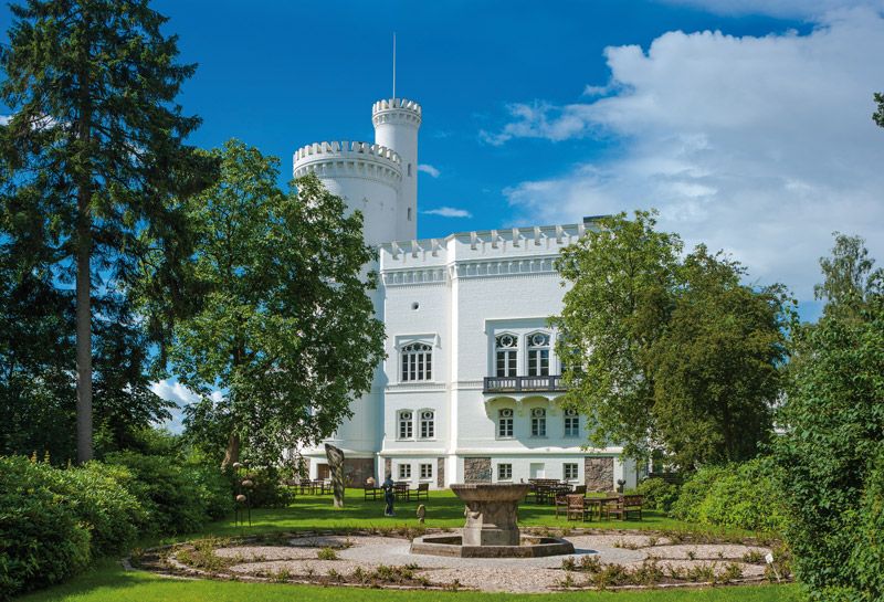 die weiße Blomenburg mit einem prachtvollen Garten im Vordergrund