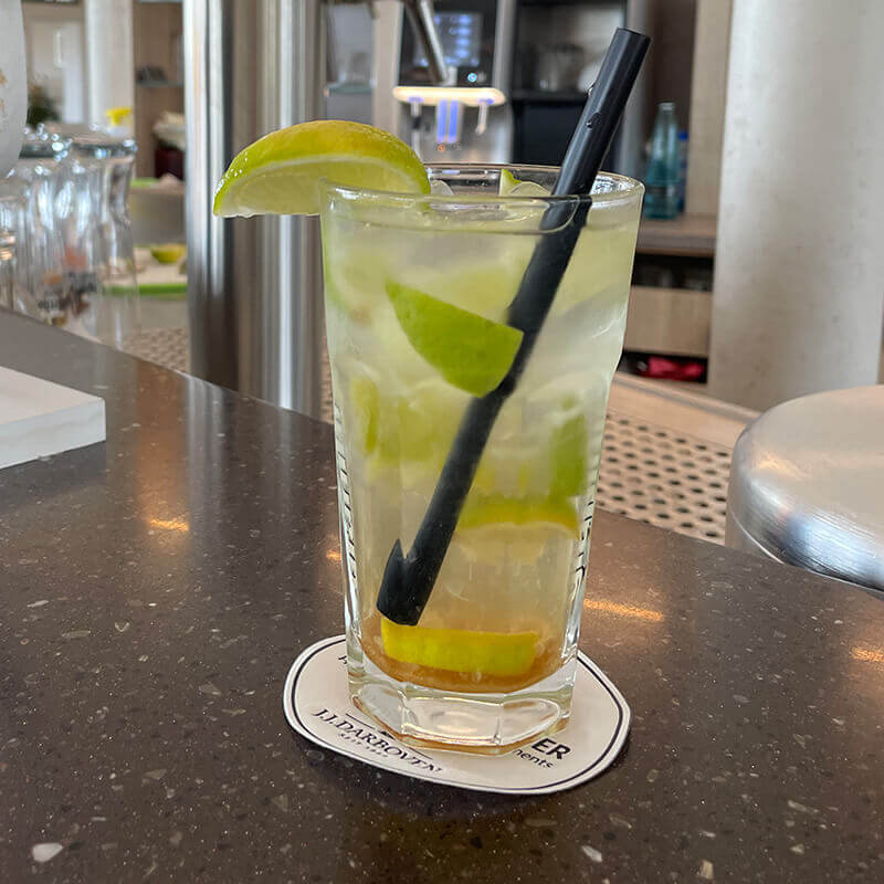 Cocktail mit Limetten und einem Strohhalm