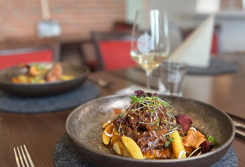 köstliches Essen auf einem gedeckten Tisch und roten Stühlen im Hintergrund