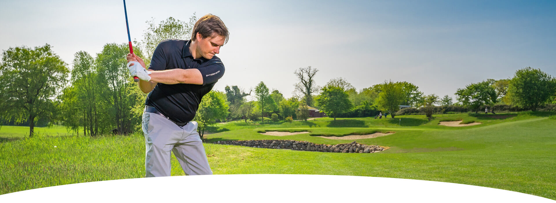 ein Golfspieler der gerade zum Schlag ausholt, er ist auf dem Hohwachter Golfplatz