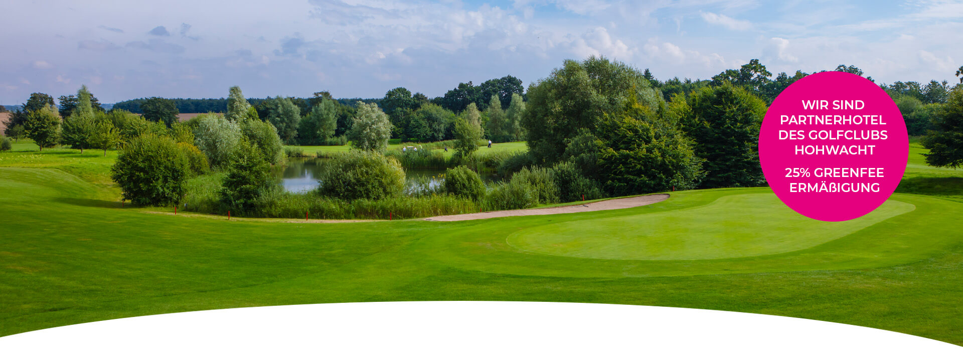 grüner Golfplatz in Hohwacht mit Teich in der Mitte, ein pinker Kreisbanner mit der Aufschrift ,, Wir sind Partnerhotel des Golfclubs Hohwacht 25% Greene Ermäßigung" ist rechts im Bild
